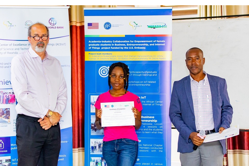 Damien Hanyurwimfura, Director of African Center of Excellence in Internet of Things and Jeffrey T Cole, Grants Officer at US Embassy pose for a photo after presenting a certificate to one of the graduates.